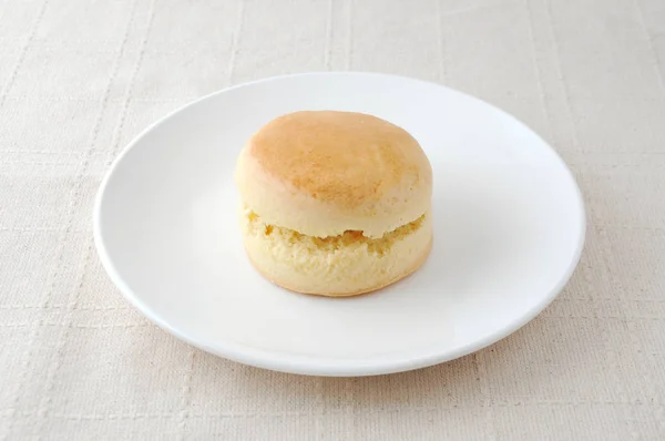 Einfacher Scone-Keks auf einem Teller auf Tischdecke — Stockfoto