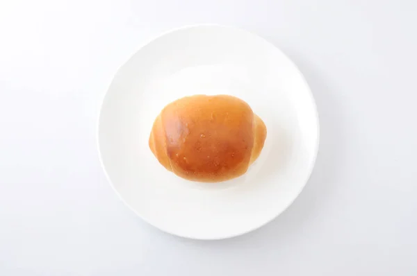 Rollo de pan de mantequilla en un plato aisladosobre fondo blanco — Foto de Stock