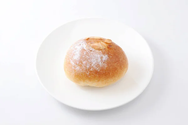 Rollo de pan de mantequilla en un plato sobre fondo blanco — Foto de Stock