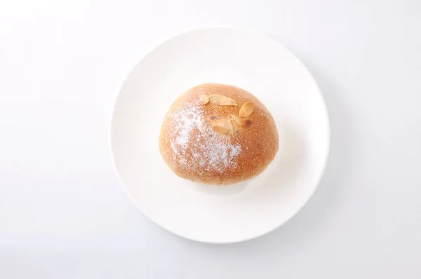 Rollo de pan de mantequilla en un plato sobre fondo blanco — Foto de Stock