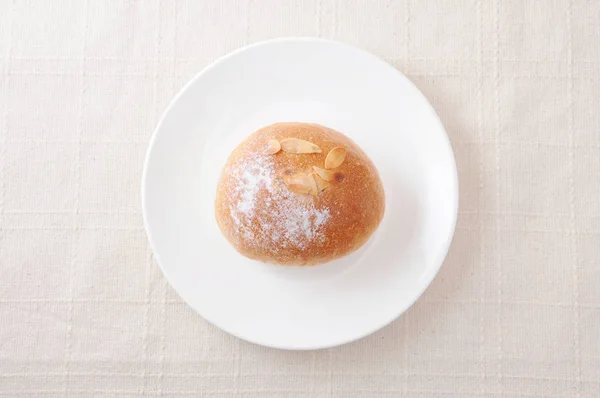 Rollo de pan de mantequilla en un plato en mantel — Foto de Stock