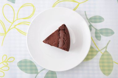 masa örtüsü üzerinde bir tabak üzerinde çikolatalı kek gateau chocola parçası