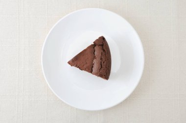 masa örtüsü üzerinde bir tabak üzerinde çikolatalı kek gateau chocola parçası