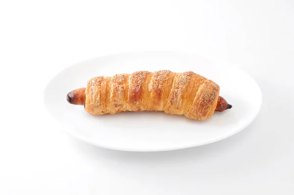 Pan rollo de salchicha en plato sobre fondo blanco — Foto de Stock