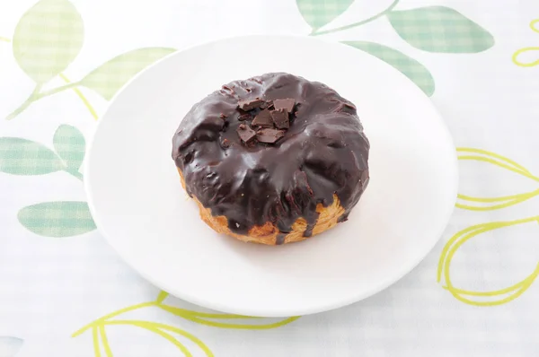 Schokoladenkuchen auf Teller auf Tischdecke — Stockfoto