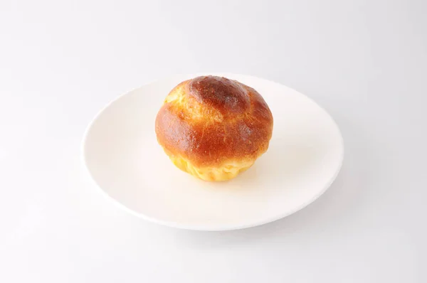 Brioche uma tete em uma chapa no fundo branco — Fotografia de Stock