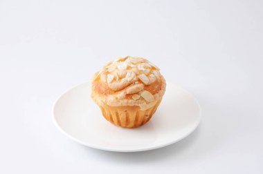 beyaz arka plan üzerinde bir tabak üzerinde badem ve suggar ile fincan kek muffin