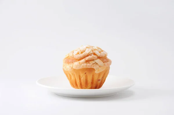 Beker cake muffin met amandel en suggar op een bord op witte achtergrond — Stockfoto