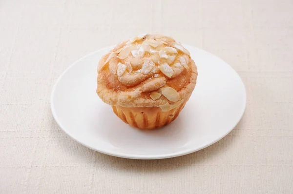 Bolo de copo muffin com amêndoa e açúcar em uma placa na toalha de mesa — Fotografia de Stock