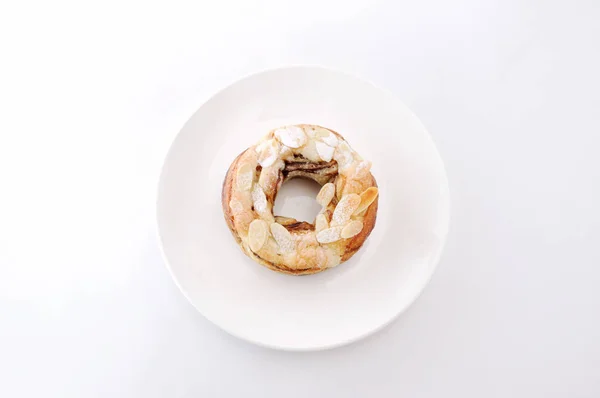 Rosquilla de pastel de almendras dulces sobre un plato fondo blanco — Foto de Stock