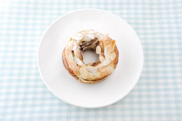 Rosquilla de pastel de almendras dulces en un paño de tabla de plato — Foto de Stock