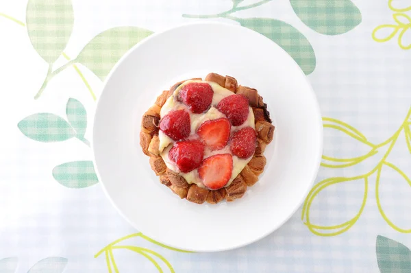 Pastel de fresa con crema de natillas en un plato sobre un paño de mesa — Foto de Stock