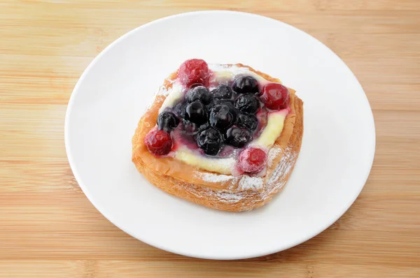 Pastel de arándanos con crema de natillas en un plato en la mesa — Foto de Stock