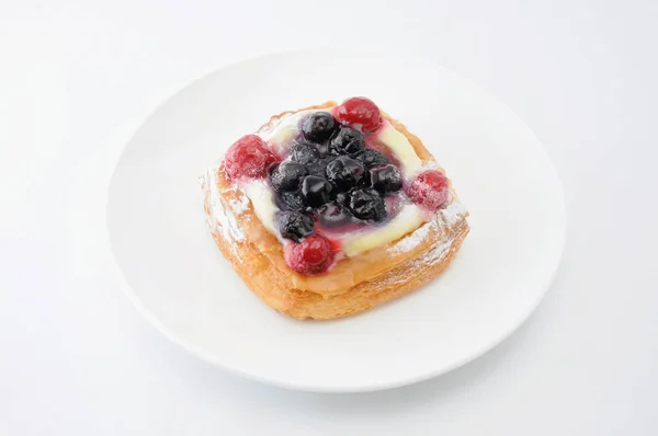 Pastel de arándanos con crema de natillas en un plato sobre fondo blanco — Foto de Stock