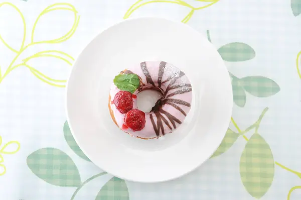 Rosquilla de pastel de fresa dulce en un plato en un paño de tabla — Foto de Stock