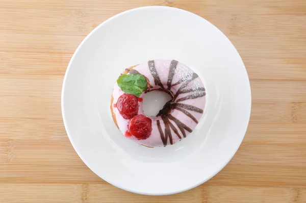 Rosquilla de pastel de fresa dulce en un plato en la mesa — Foto de Stock