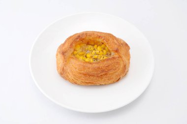 beyaz arka plan üzerinde tabakta mısır danimarka ekmeği