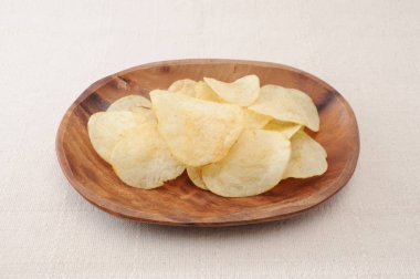 masa örtüsü üzerinde ahşap tabak üzerinde patates cipsi