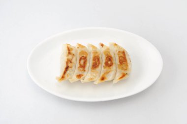 Kızarmış Köfte Gyoza. Beyaz arka plan üzerinde plaka üzerine süslenmiş