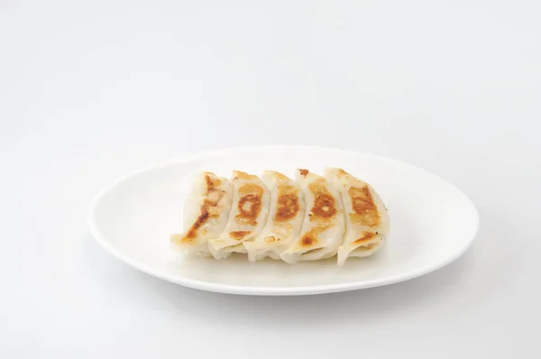 揚げ餃子餃子。白い背景にプレートに飾られた — ストック写真