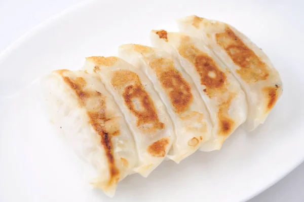 Kızarmış Köfte Gyoza. Beyaz arka plan üzerinde plaka üzerine süslenmiş — Stok fotoğraf