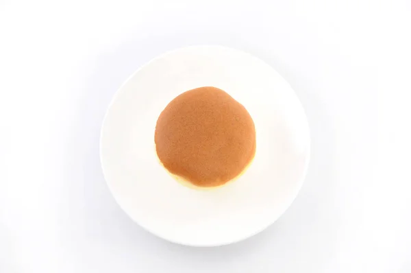 Pastel de esponja redonda en el plato sobre fondo blanco — Foto de Stock