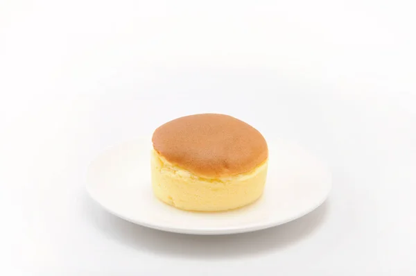 白色背景的盘子上的圆形海绵蛋糕 — 图库照片