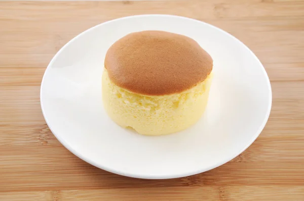 Pastel de esponja redonda en el plato en la mesa — Foto de Stock