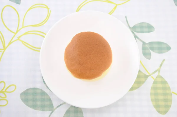 Pastel de esponja redonda en el plato en la mesa — Foto de Stock