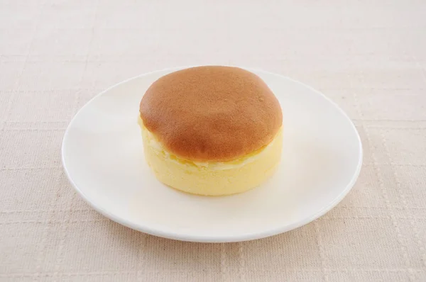 Pastel de esponja redonda en el plato en la mesa —  Fotos de Stock