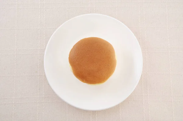 Pastel de esponja redonda en el plato en la mesa — Foto de Stock