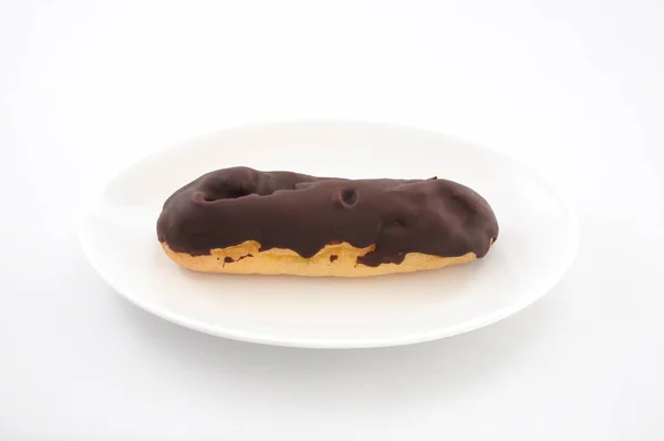 Cioccolato eclair crema soffio sul piatto su sfondo bianco — Foto Stock