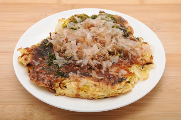 Okonomiyaki japoński naleśnik żywności na talerzu na stole — Zdjęcie stockowe