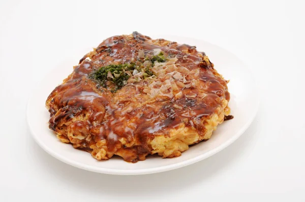 Okonomiyaki japoński naleśnik na płycie na białym tle — Zdjęcie stockowe