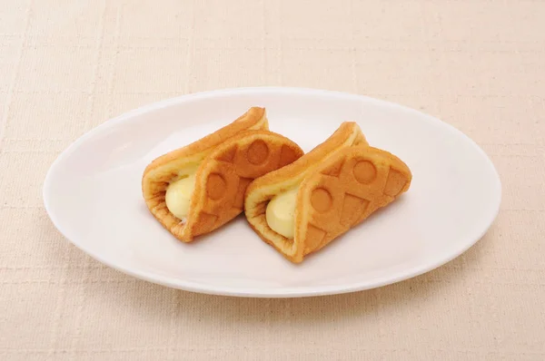 Wafel custard cream roll di piring di atas meja — Stok Foto