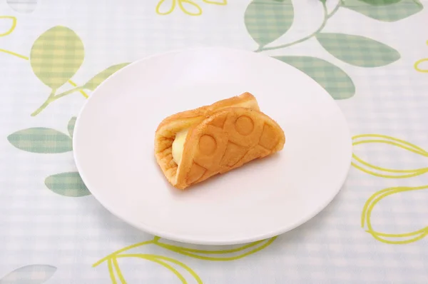 Wafel custard cream roll di piring di atas meja — Stok Foto