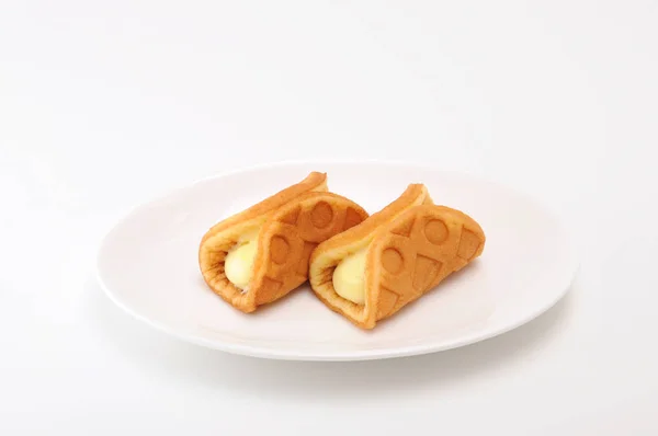 Natillas de gofre rollo de crema en la placa sobre fondo blanco — Foto de Stock