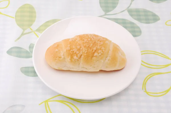 Salty butter roll bread on plate on table — Stock Photo, Image