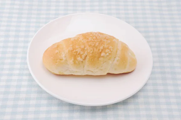 Salty butter roll bread on plate on table — Stock Photo, Image