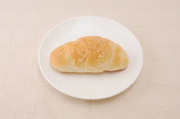 Salty butter roll bread on plate on table — Stock Photo, Image