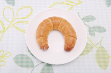 masa örtüsü üzerinde tabakta hilal rulo kruvasan fransız ekmeği