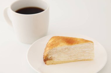 beyaz arka plan üzerinde bir tabak üzerinde Mille krep fransız kek ile sıcak kahve