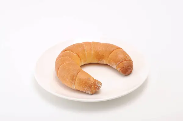 Crescente rolo croissant francês pão na placa no fundo branco — Fotografia de Stock