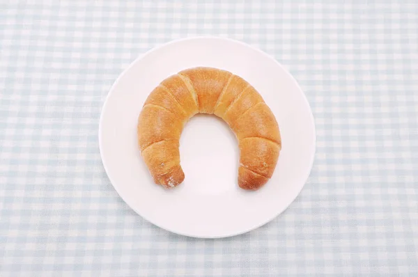 Crescent roll croissant french bread on plate on table cloth — Stock Photo, Image