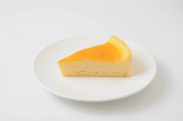 Pedaço de bolo de queijo fresco na placa isolado no fundo branco — Fotografia de Stock