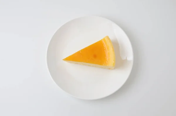 Pedaço de bolo de queijo fresco na placa isolado no fundo branco — Fotografia de Stock