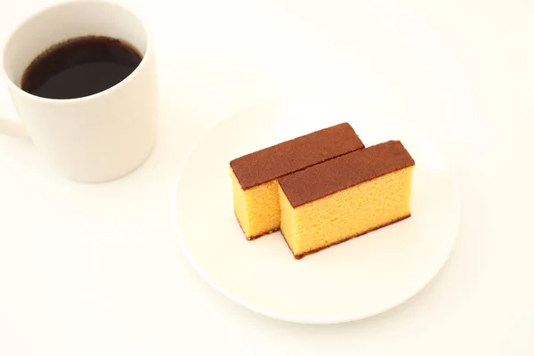 Castella japanischer Biskuitkuchen auf Teller mit heißem Kaffee auf weißem Hintergrund — Stockfoto