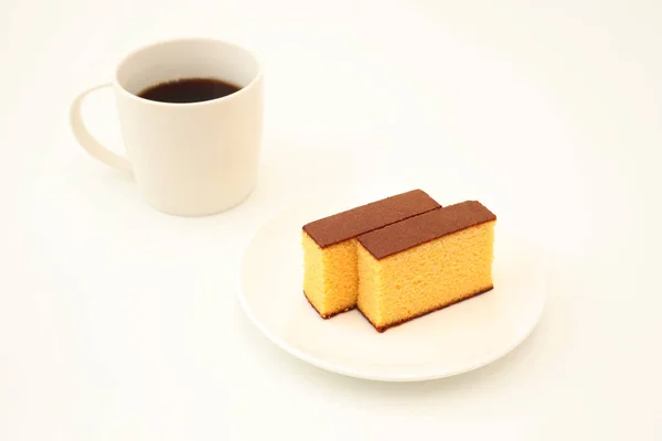 Castella japonês esponja bolo na placa com café quente no fundo branco — Fotografia de Stock