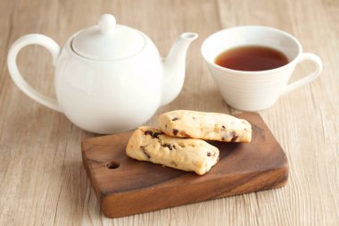 kurutulmuş meyve masada çaydanlık ve çay bardağı ile scone
