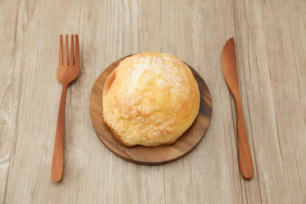 sugar bread melon pan on wood plate fork knife isolated on table